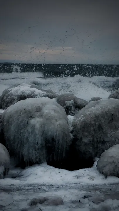 A storm breaking over ice-covered rocks